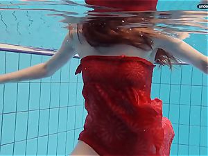 crimson dressed teenage swimming with her eyes opened